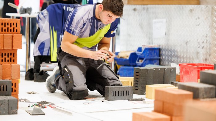 WorldSkills Competition 2022 Special Edition: Südtiroler holt Medallion for Excellence Handwerker misst Ziegelsteine während Bauarbeit und Planung