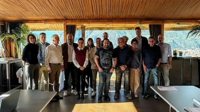 Südtiroler Handwerk: Unternehmen und Gewerkschaften gemeinsam für ein stärkeres bilaterales System Gruppenfoto von 15 Personen in einem Raum mit Bergblick