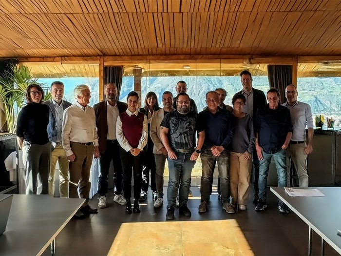 Südtiroler Handwerk: Unternehmen und Gewerkschaften gemeinsam für ein stärkeres bilaterales System Gruppenfoto von 15 Personen in einem Raum mit Bergblick