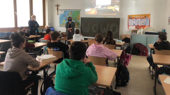 Traumberufe im Handwerk und in der Gastronomie Schüler in Klassenzimmer schauen auf projizierten Bildschirm, Lehrer mit Maske