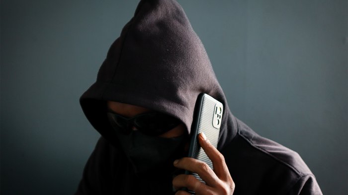 L'artigianato unisce i mondi – Perché Shanghai è più vicina di quanto si pensi Persona con cappuccio e maschera che parla al telefono in modo nascosto