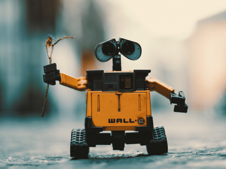 Digitale Lösungen Spielzeugroboter WALL-E hält einen Zweig auf einer Straße