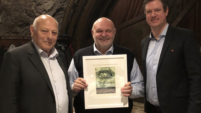 Bilaterale Körperschaft: verdiente Akteure geehrt Drei Männer in Anzügen, einer hält einen gerahmten Kunstdruck