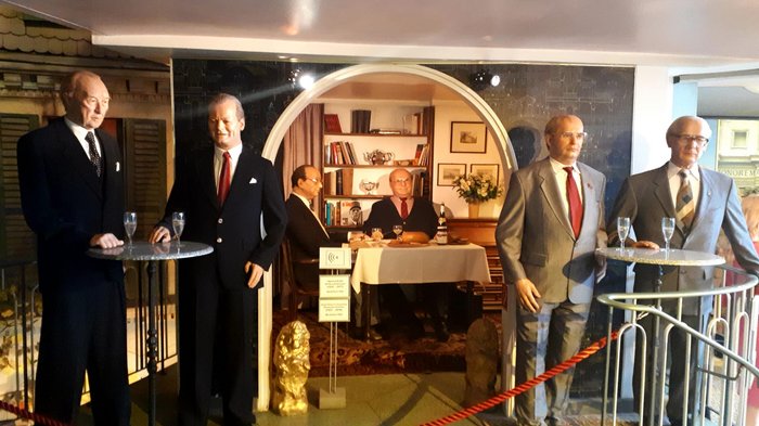 Die Althandwerker besuchen Hamburg Wachsfiguren historischer Männer in Anzügen vor und in einem Raum mit Bücherregal