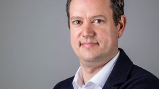 lvh-Präsident Martin Haller, Foto: © Armin Huber Porträt eines Mannes mit weißem Hemd und dunklem Jackett vor grauem Hintergrund