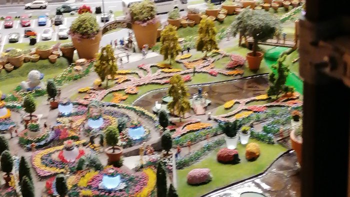 Die Althandwerker besuchen Hamburg Modell eines bunten Blumengartens mit Figuren, Teich und Miniaturzügen im Hintergrund