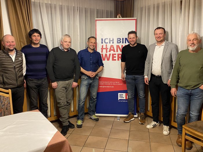 La riunione dei gruppi comunali di Aldino, Anterivo e Trodena di lvh.apa offre stimoli per il futuro Sette uomini in piedi accanto a uno striscione con la scritta Ich bin Handwerk