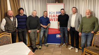 News Sieben Männer stehen neben einem Banner mit der Aufschrift Ich bin Handwerk