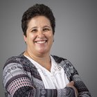 Ingrid Müller Donna sorridente con capelli corti e giacca a motivi davanti a sfondo grigio