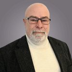 Das lvh-Team Porträt eines älteren Mannes mit Brille und grauem Bart vor grauem Hintergrund