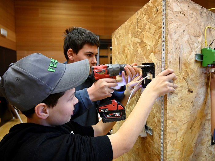 Giornata dell’artigianato a San Genesio Due ragazzi installano un impianto elettrico su una tavola di legno