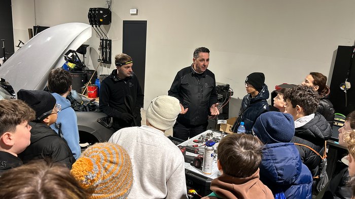 Zwei Südtiroler Projekte mit German Design Award ausgezeichnet Gruppe von Jugendlichen hört einer Erklärung in einer Autowerkstatt zu