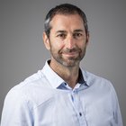 Consulenza fiscale, contabilità e calcolo della busta paga Uomo con capelli grigi e camicia azzurra su sfondo grigio