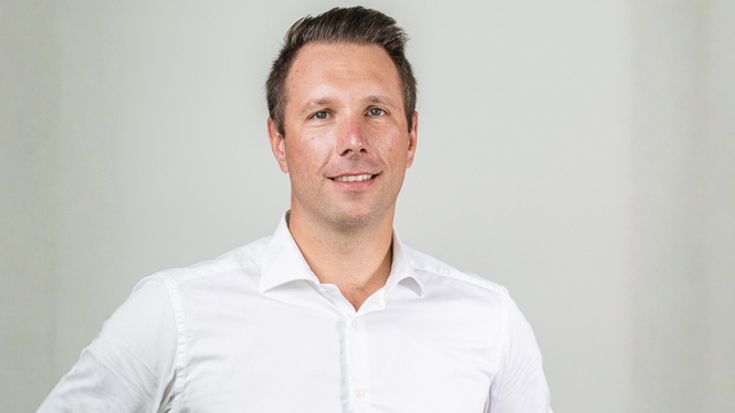 Ritratto di uomo con camicia bianca su sfondo neutro