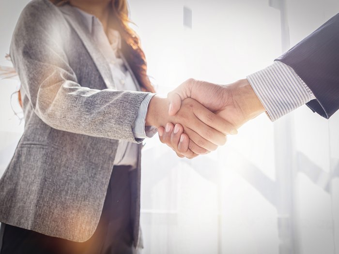 Arbeitsverdienststern 2025 – Jetzt Vorschläge einreichen! Zwei Geschäftspersonen geben sich die Hand bei einem Treffen