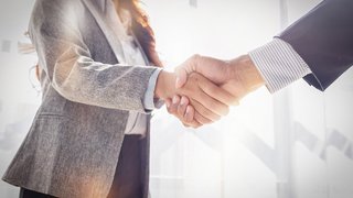 News Zwei Geschäftspersonen geben sich die Hand bei einem Treffen