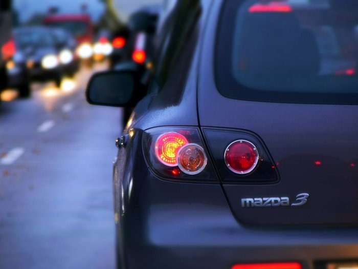 Traffico sulla MeBo: una situazione insostenibile per l’economia Vista posteriore di una Mazda 3 nel traffico serale con luci posteriori accese