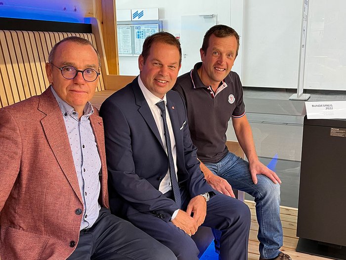 lvh-Direktor Thomas Pardeller, lvh-Vizepräsident Hannes Mussak und Manfred Spiess © lvh.apa Drei Männer in Anzug und Freizeitkleidung sitzen auf einer Holzbank in modernem Raum