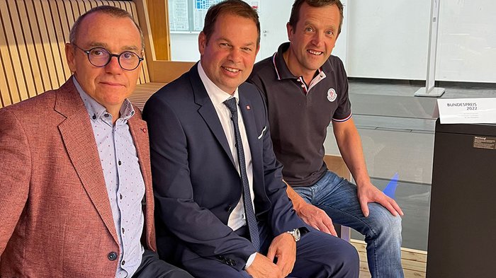 lvh-Direktor Thomas Pardeller, lvh-Vizepräsident Hannes Mussak und Manfred Spiess © lvh.apa Drei Männer in Anzug und Freizeitkleidung sitzen auf einer Holzbank in modernem Raum