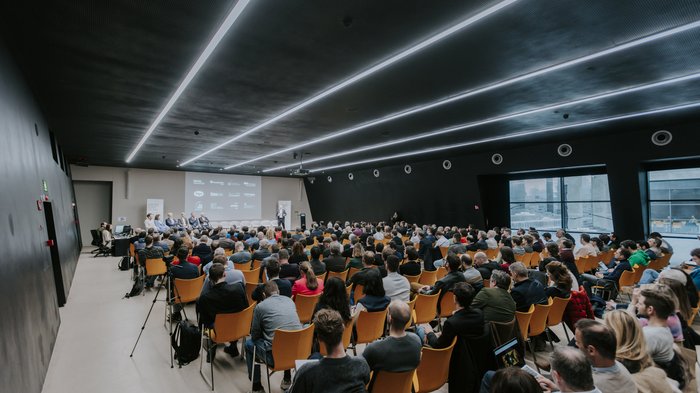Anlaufstelle für Künstliche Intelligenz vorgestellt Großer Konferenzraum mit Publikum und Redner auf der Bühne