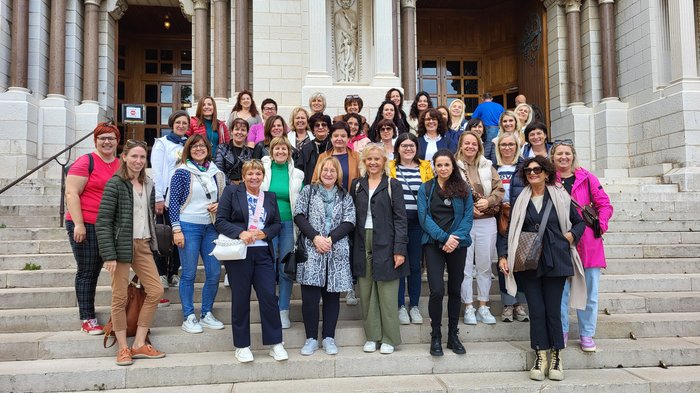 Die Frauen im Handwerk an der Côte d'Azur: Jetset, Genuss und königliche Begegnungen Gruppenfoto von Frauen auf einer Treppe vor einem historischen Gebäude