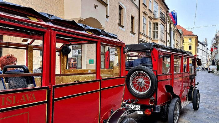 Auf Reisen: Althandwerker auf Flusskreuzfahrt Rotes Touristenfahrzeug in der Altstadt von Bratislava