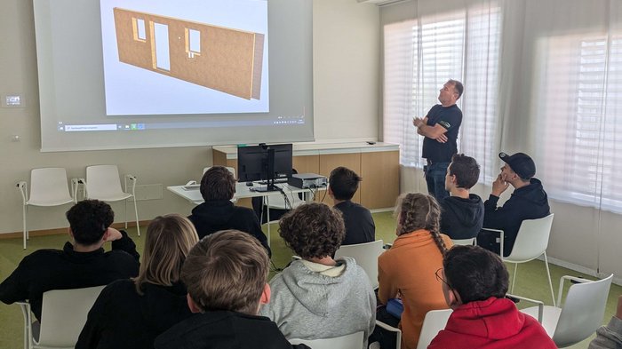 „Handwerk trifft Schule“ – Ein starkes Projekt für die Zukunft! Lehrer erklärt Architekturmodell vor Schülern in einem Klassenzimmer