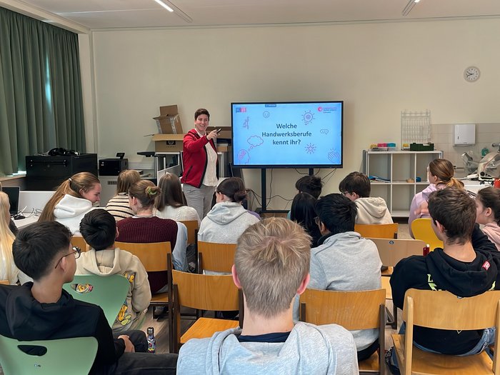 Scuola media di Colle Isarco: fare esperienza pratica delle professioni Insegnante presenta mestieri artigianali a studenti in aula