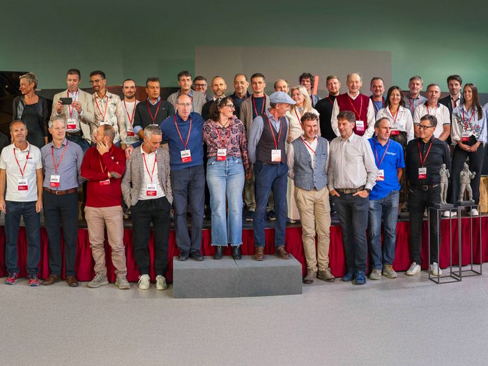 Die 31. UNIKA-Kunstmesse eröffnet in St. Ulrich Große Gruppe von Menschen mit Namensschildern steht in einem Raum mit Statuen