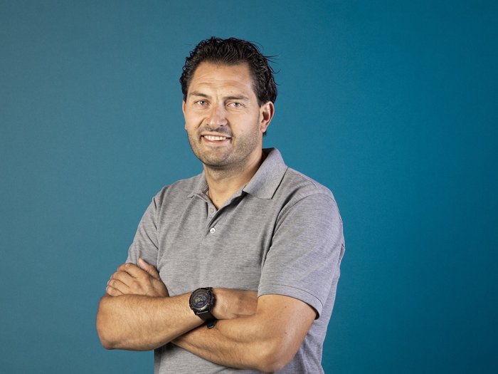 Energieförderung 2025: Wärmepumpen-Offensive bringt Schwung für Südtirols Handwerk Mann mit verschränkten Armen und grauem Poloshirt vor blauem Hintergrund