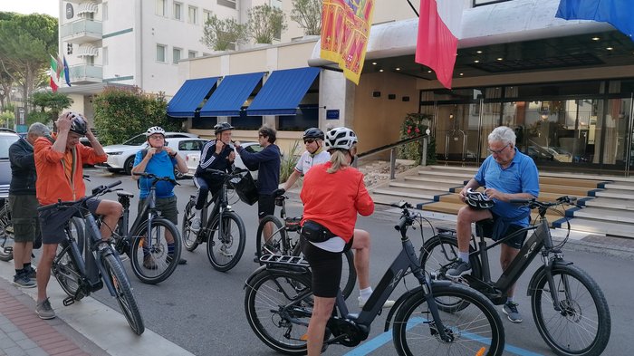 Badespaß an der Adria Gruppe älterer Radfahrer macht Pause vor einem Hotel mit mehreren Flaggen