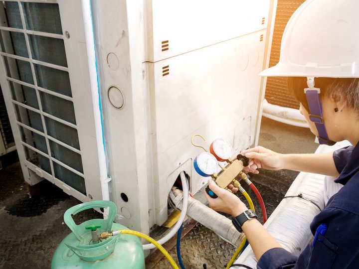 Kälte- und Klimatechniker Techniker überprüft Klimaanlage mit Manometer-Set und Gasflasche