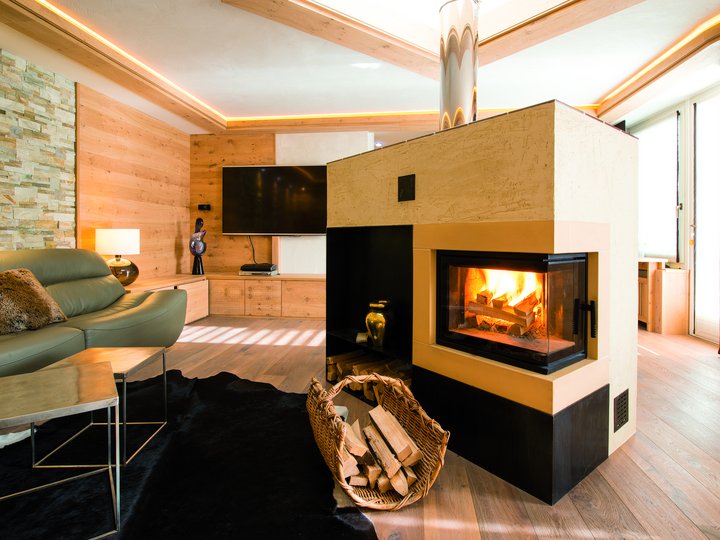 Ausbildung Gemütliches Wohnzimmer mit Kamin, grünem Sofa und moderner Holzverkleidung