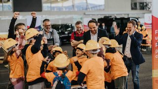 News Kinder mit Schutzhelmen feiern im Beisein erwachsener Betreuer in einer Halle