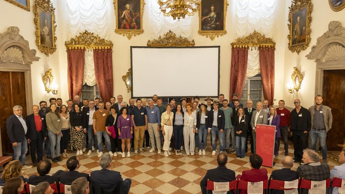 30 anni di WorldSkills South Tyrol, Italy: un percorso avvincente nella formazione professionale Foto di gruppo in una sala elegante con dipinti e lampadario