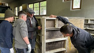 News Mehrere Personen inspizieren eine große Betonform in einer Werkstatt