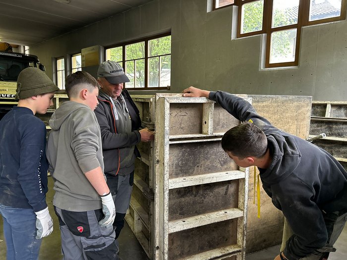 Handwerk hautnah erleben: Die Sarner Mittelschüler/innen entdecken ihre berufliche Zukunft Mehrere Personen inspizieren eine große Betonform in einer Werkstatt