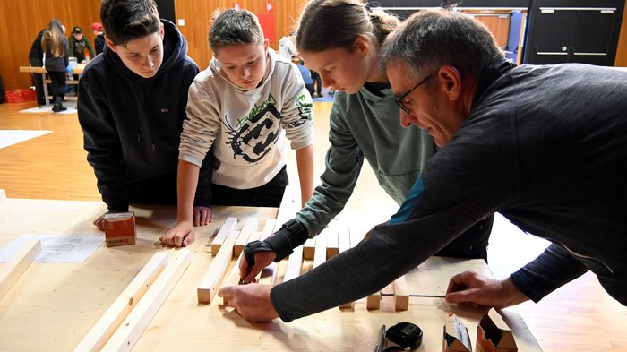 Tag des Handwerks in Jenesien Erwachsener zeigt Schülern Holzarbeiten in einer Werkstatt