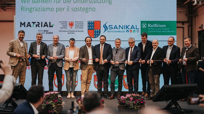 Erfolgreiche Eröffnung der Eisacktaler Wirtschaftsschau in Brixen – Ein Schaufenster der lokalen Wirtschaftskraft Personen bei einer Banddurchschneidung vor einer Dankesleinwand mit Sponsorenlogos