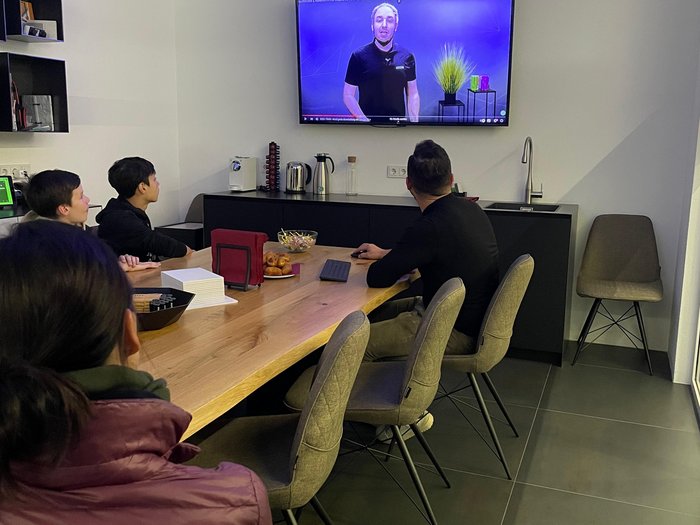 Berufsinformationskampagne Mittelschule Karl Meusburger Personen schauen eine Präsentation an einem Bildschirm in einem Besprechungsraum.