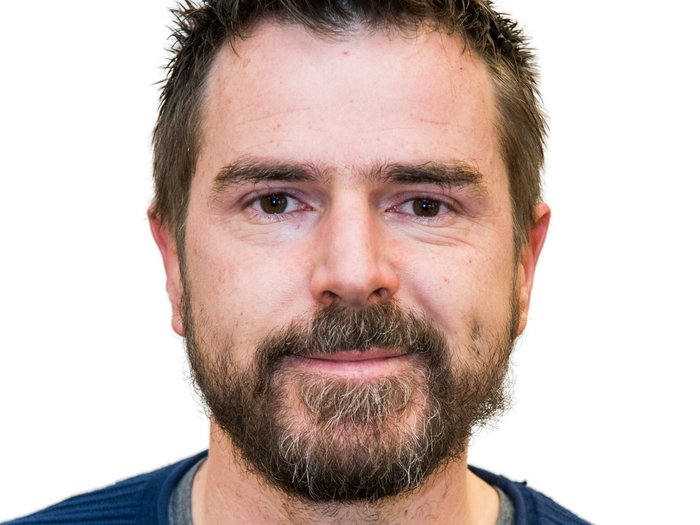 Junges Handwerk in Deutschnofen Porträt eines Mannes mit Bart und blauem Pullover vor weißem Hintergrund