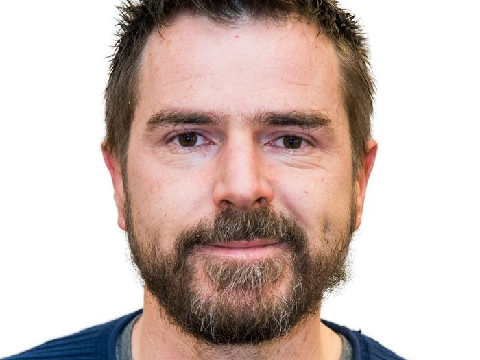 Junges Handwerk in Deutschnofen Porträt eines Mannes mit Bart und blauem Pullover vor weißem Hintergrund