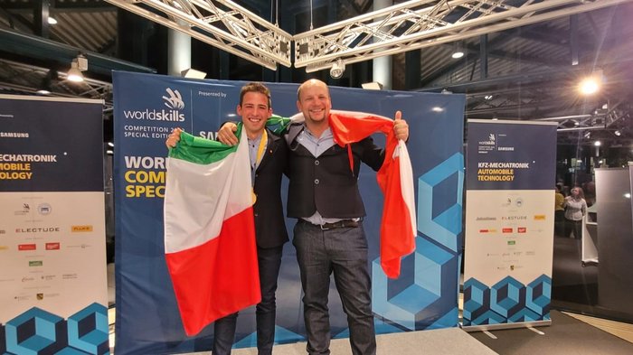 Gold und Medaillon for Excellence für Südtirol Zwei Männer mit italienischer Flagge bei WorldSkills Wettbewerb für KFZ-Mechatronik