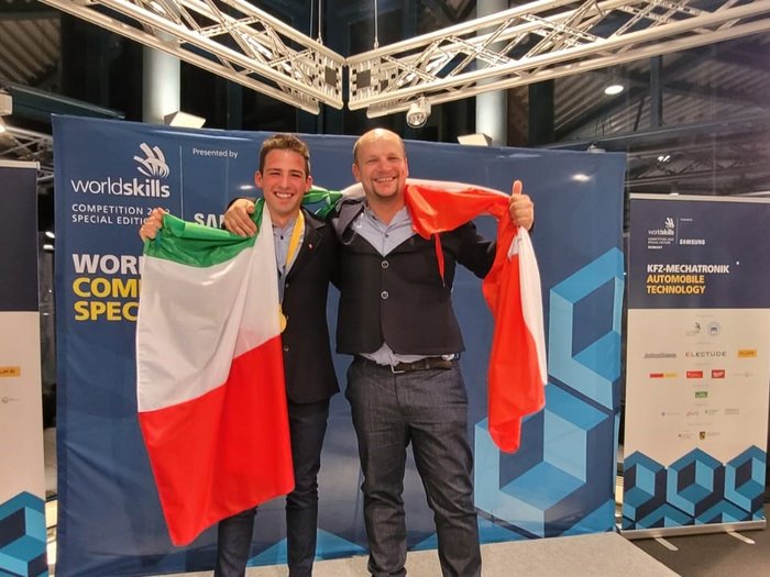 Oro e medaglia d'eccellenza per l'Alto Adige Due uomini con bandiera italiana alla competizione WorldSkills per meccatronica automobilistica