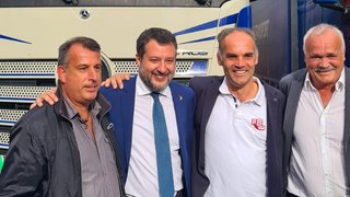 News Vier Männer stehen lächelnd vor einem Lastwagen