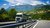 Camion su un'autostrada davanti a un paesaggio montano verde