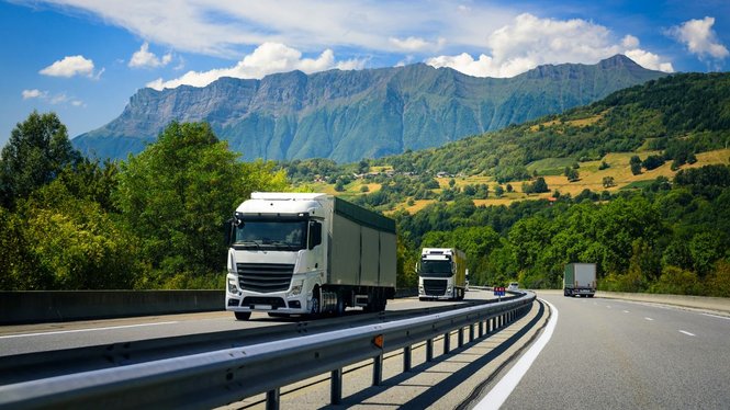 Home Camion su un'autostrada davanti a un paesaggio montano verde