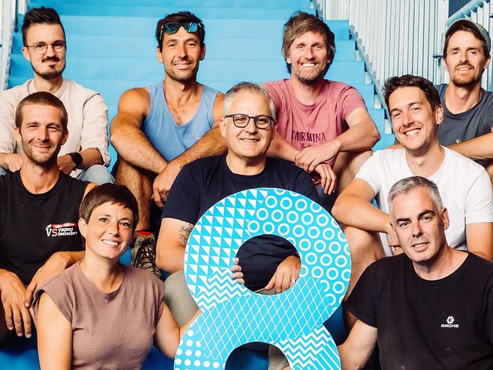 Rittner Musterschau: Der Ritten wird zur Bühne für Wirtschaft und Ideen Gruppe von neun Personen sitzt auf blauen Treppen, hält große blaue Zahl 8