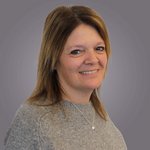 Das lvh-Team Porträt einer lächelnden Frau mit braunen Haaren vor grauem Hintergrund