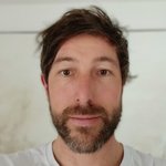 Bozen Land Nahaufnahme eines Mannes mit braunem Haar und Bart vor hellem Hintergrund